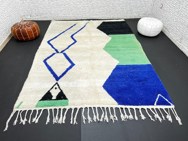 Handmade ivory Moroccan wool rug with green, blue, and black geometric abstract patterns