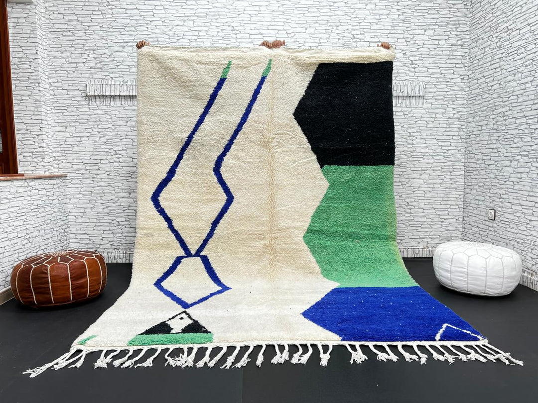 Handmade ivory Moroccan wool rug with green, blue, and black geometric abstract patterns