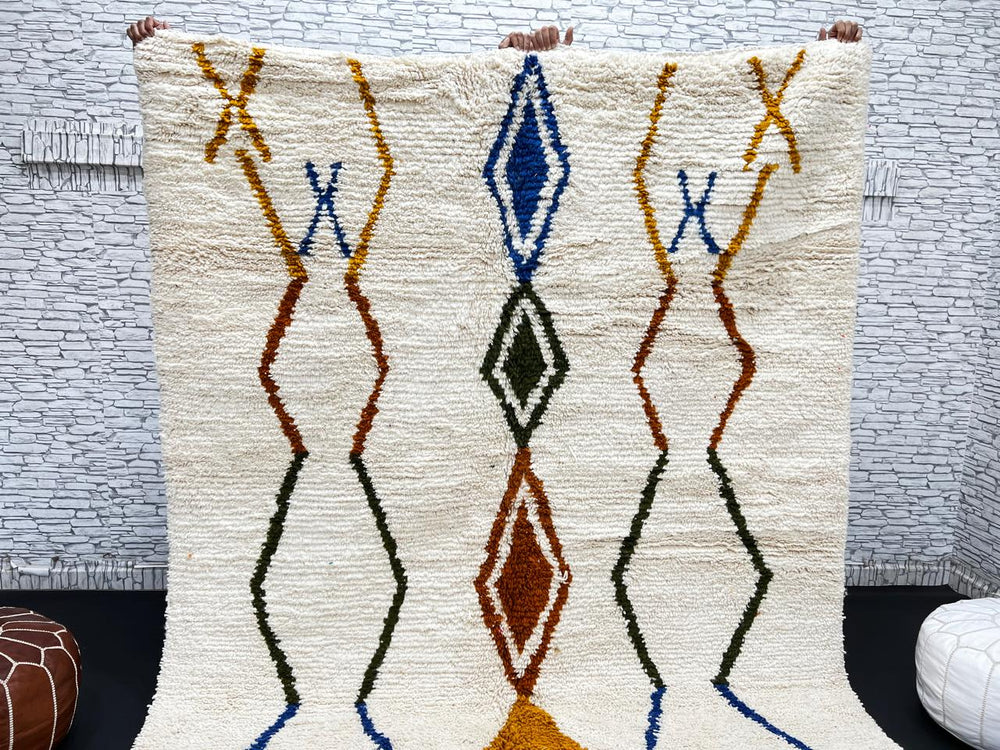 Handwoven ivory Moroccan wool rug with blue, amber, and olive geometric Berber designs