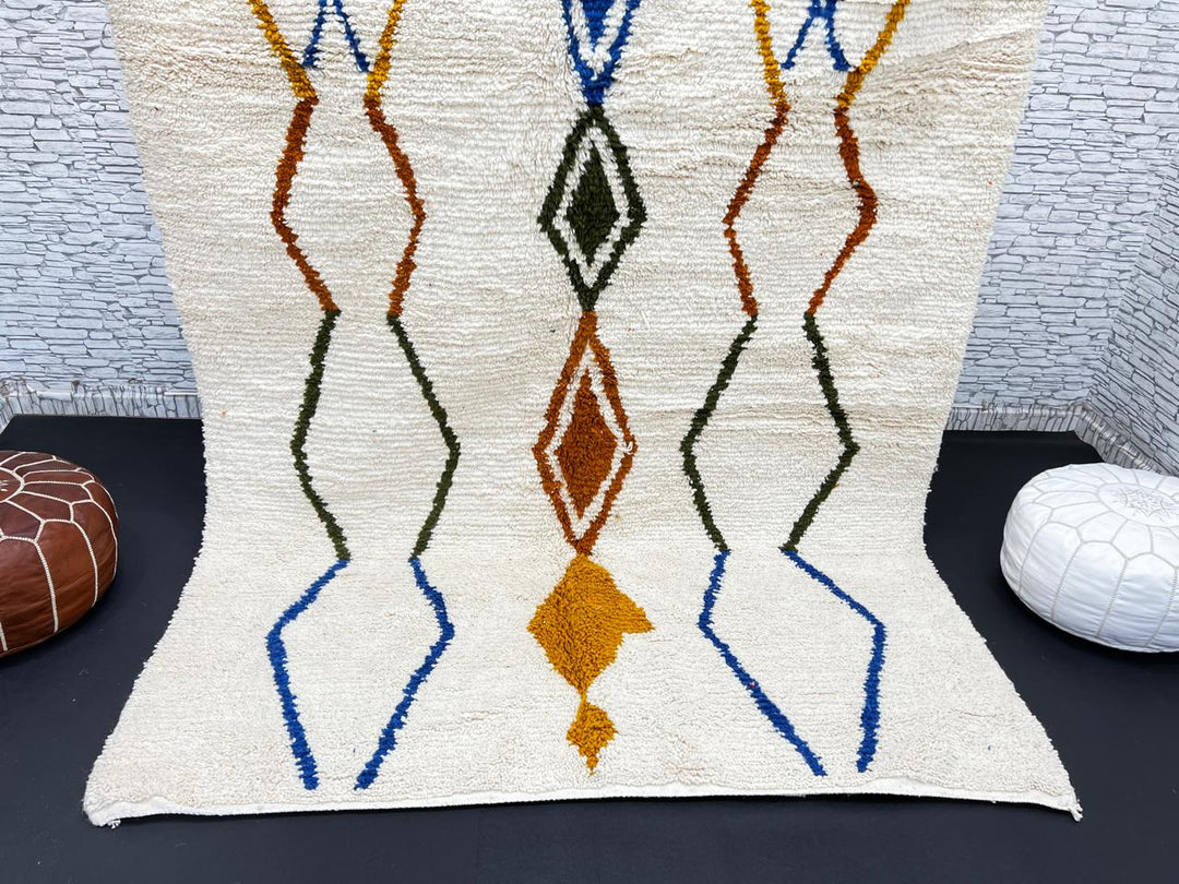 Handwoven ivory Moroccan wool rug with blue, amber, and olive geometric Berber designs