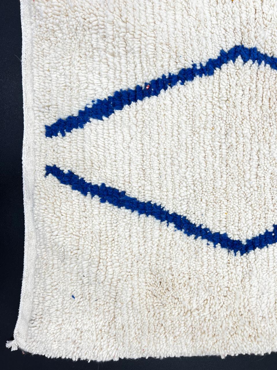 Handwoven ivory Moroccan wool rug with blue, amber, and olive geometric Berber designs