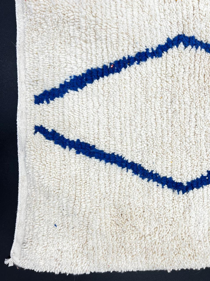 Handwoven ivory Moroccan wool rug with blue, amber, and olive geometric Berber designs