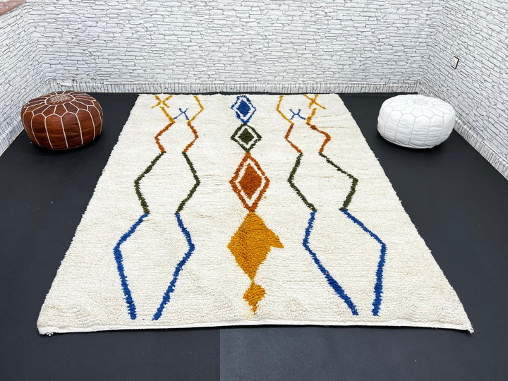 Handwoven ivory Moroccan wool rug with blue, amber, and olive geometric Berber designs