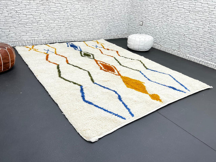 Handwoven ivory Moroccan wool rug with blue, amber, and olive geometric Berber designs