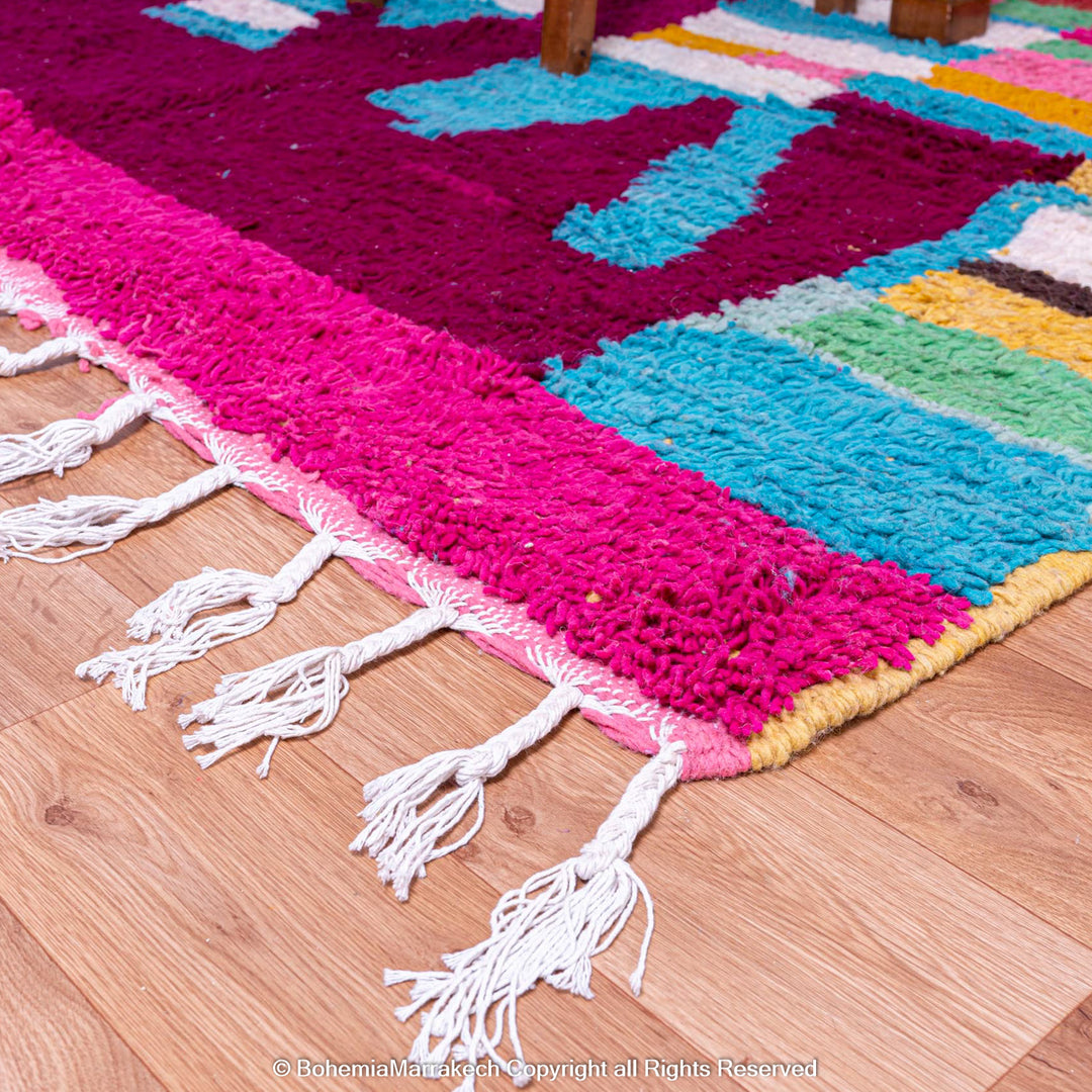 Handmade Moroccan rug with colorful striped and tribal motifs in vibrant wool