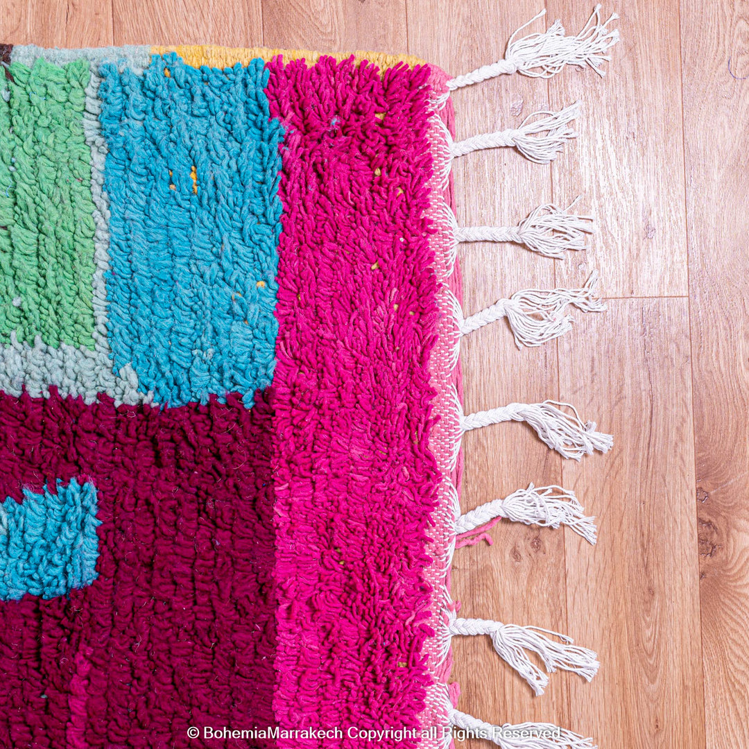 Handmade Moroccan rug with colorful striped and tribal motifs in vibrant wool