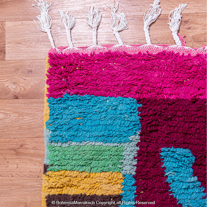 Handmade Moroccan rug with colorful striped and tribal motifs in vibrant wool