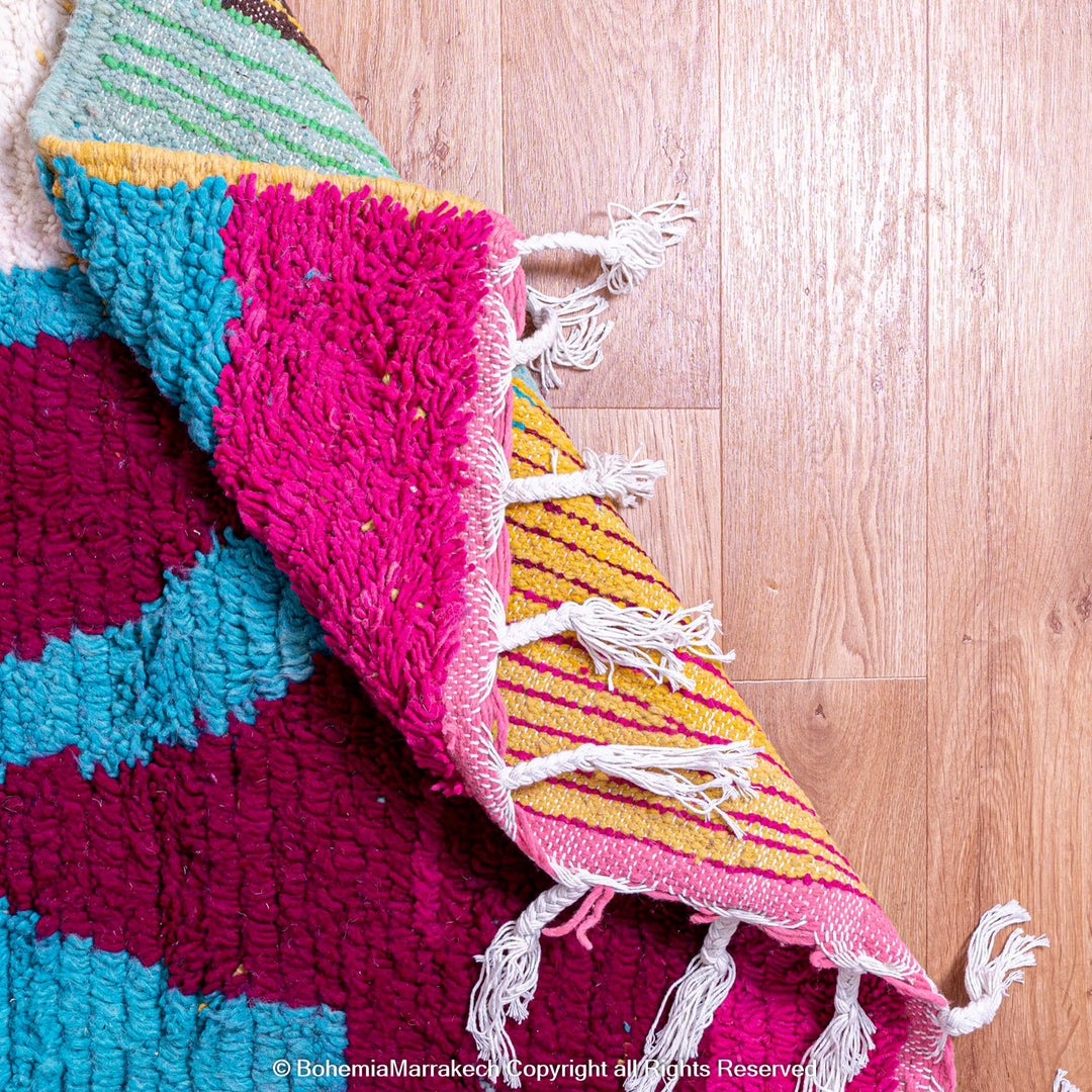 Handmade Moroccan rug with colorful striped and tribal motifs in vibrant wool