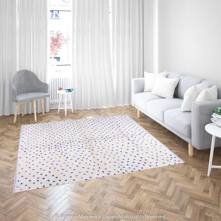 Large white Moroccan rug with blue dots in modern living room, showcasing traditional Beni Ourain craftsmanship, 100% wool.