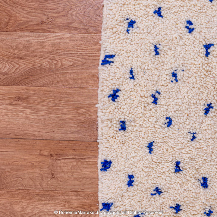 Large white Moroccan rug with blue dots, wool Beni Ourain, handcrafted Berber design. Ideal for elegant, minimalist spaces.