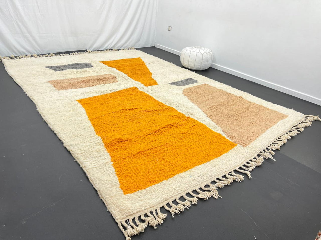 Luxury modern Moroccan wool rug with abstract ochre beige and charcoal color blocks on a cream white background