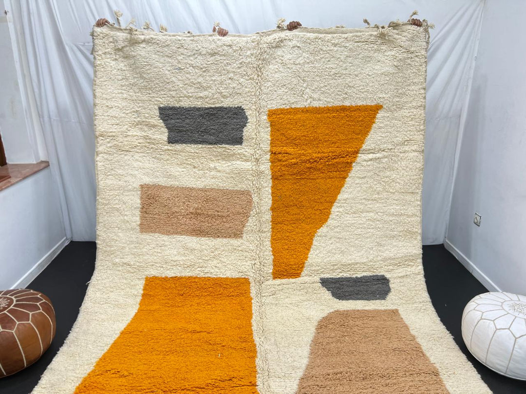 Luxury modern Moroccan wool rug with abstract ochre beige and charcoal color blocks on a cream white background