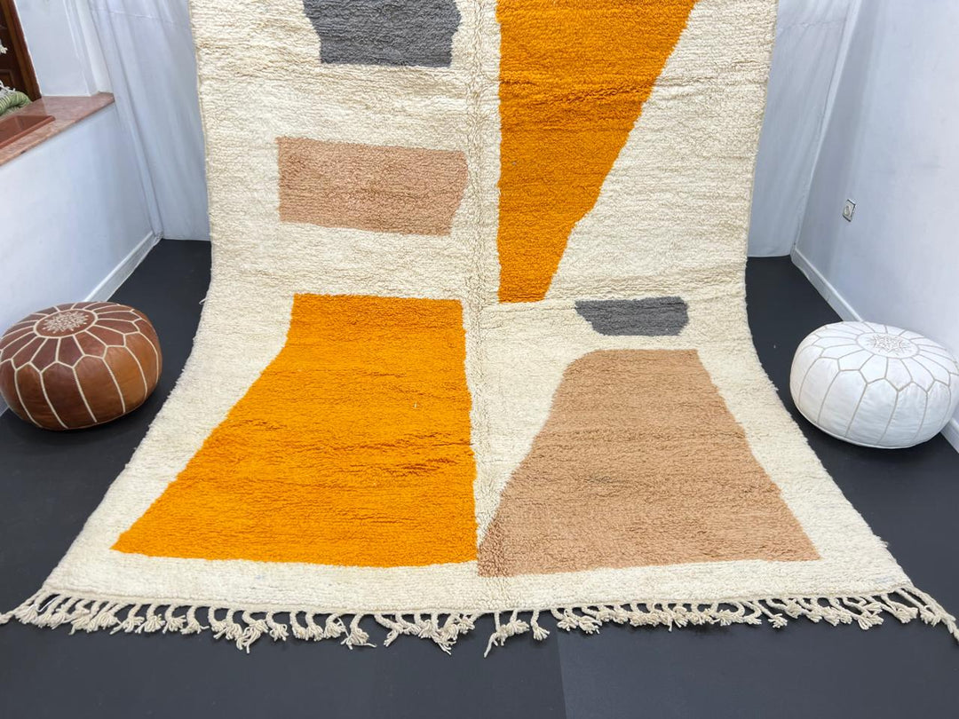 Luxury modern Moroccan wool rug with abstract ochre beige and charcoal color blocks on a cream white background