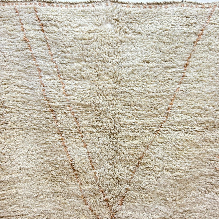 Handmade Moroccan wool runner rug in cream with subtle peach geometric lines and fringed end