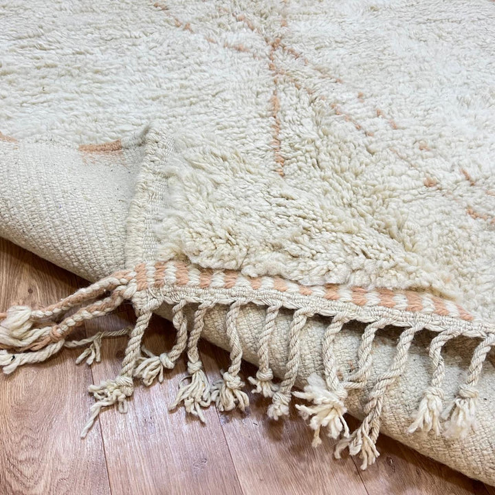 Handmade Moroccan wool runner rug in cream with subtle peach geometric lines and fringed end