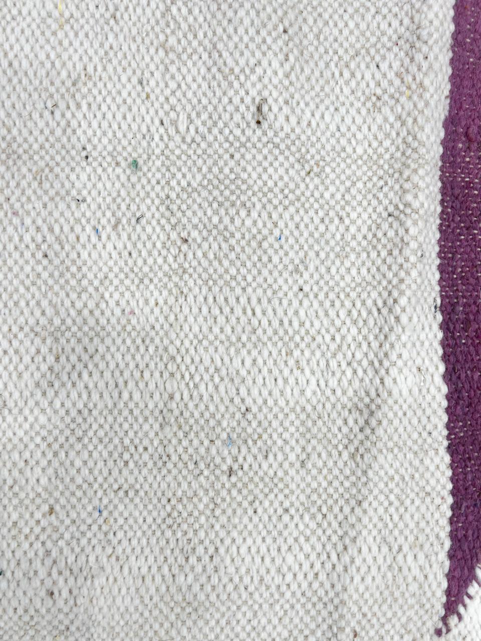 Flat weave round Moroccan wool rug with minimalist abstract pink and purple design on white background