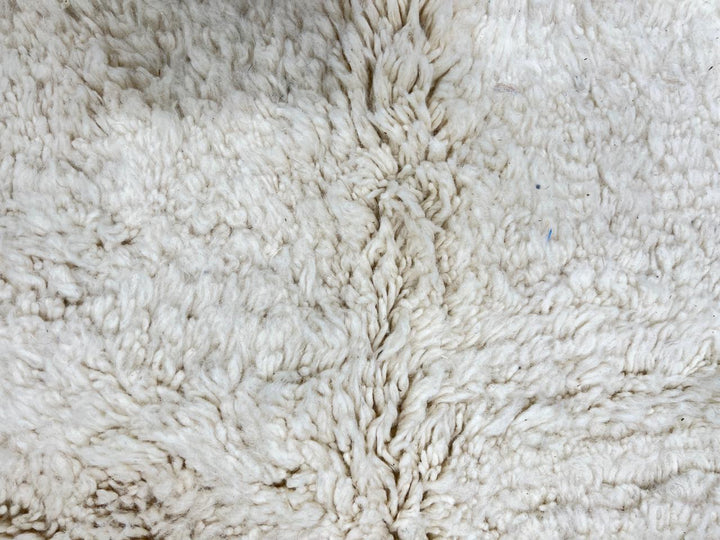 Handmade Moroccan runner rug with white wool center, blue borders, and beige accents, crafted by Berber artisans.