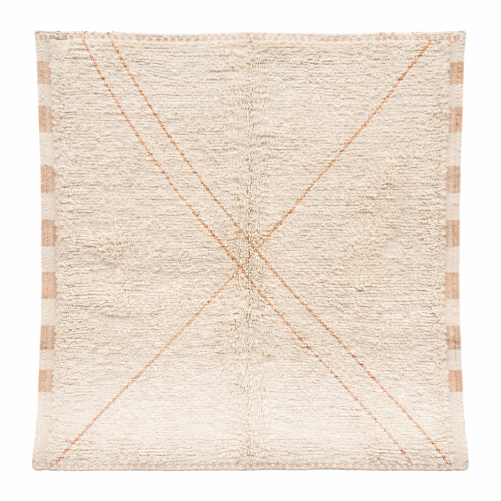 Close-up of a plush creamy beige Moroccan Beni Mrirt rug, handcrafted from soft natural wool, featuring a subtle X-shaped design.