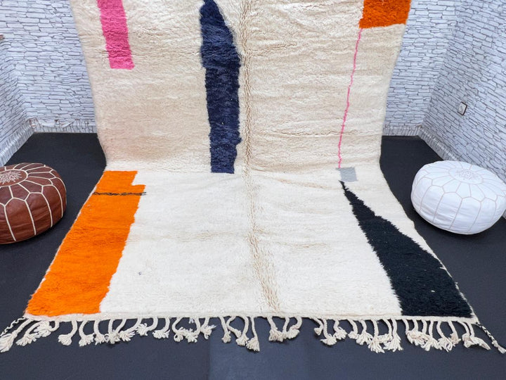 Minimalist Moroccan wool rug with abstract navy, orange and pink line design on cream background
