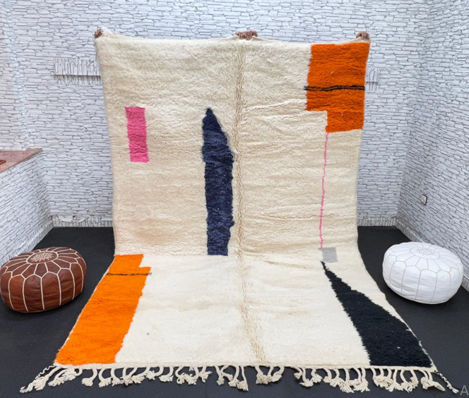 Minimalist Moroccan wool rug with abstract navy, orange and pink line design on cream background