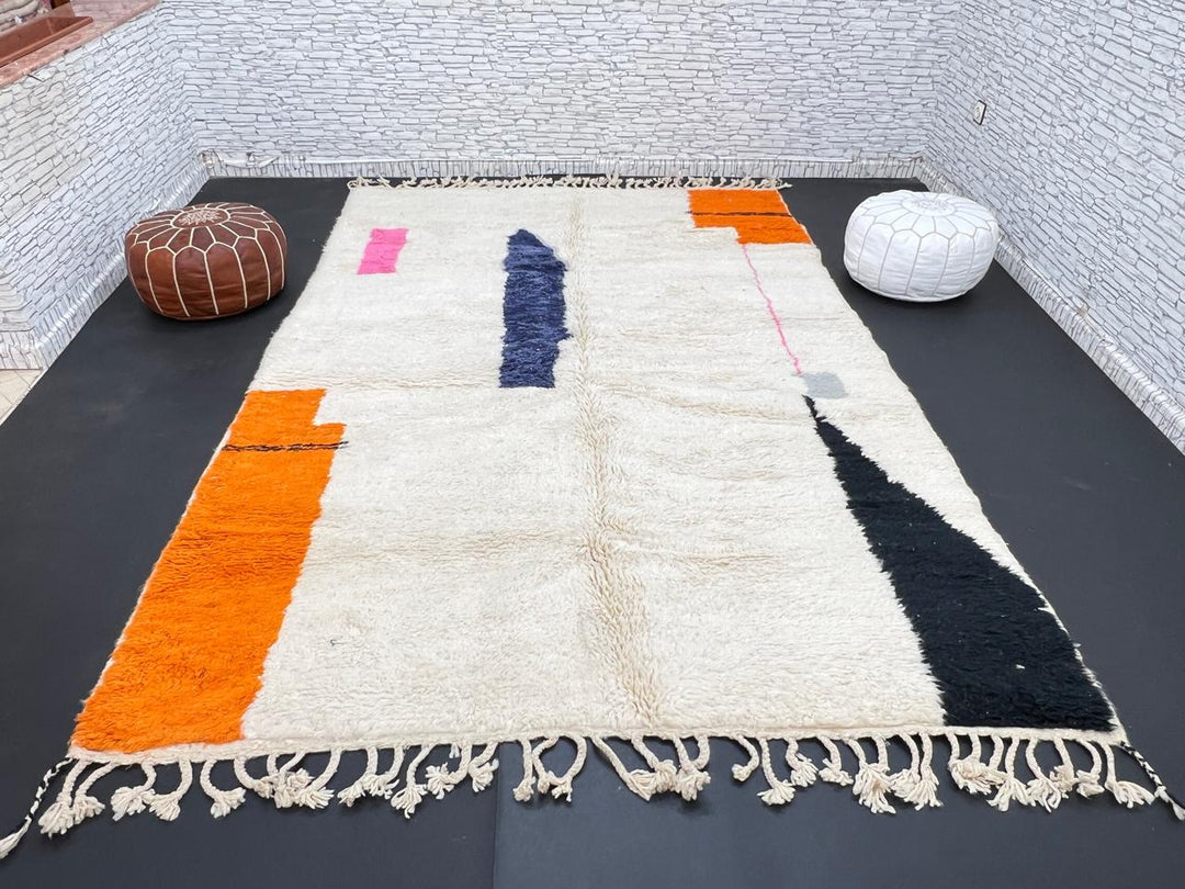 Minimalist Moroccan wool rug with abstract navy, orange and pink line design on cream background