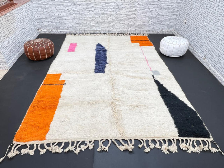 Minimalist Moroccan wool rug with abstract navy, orange and pink line design on cream background