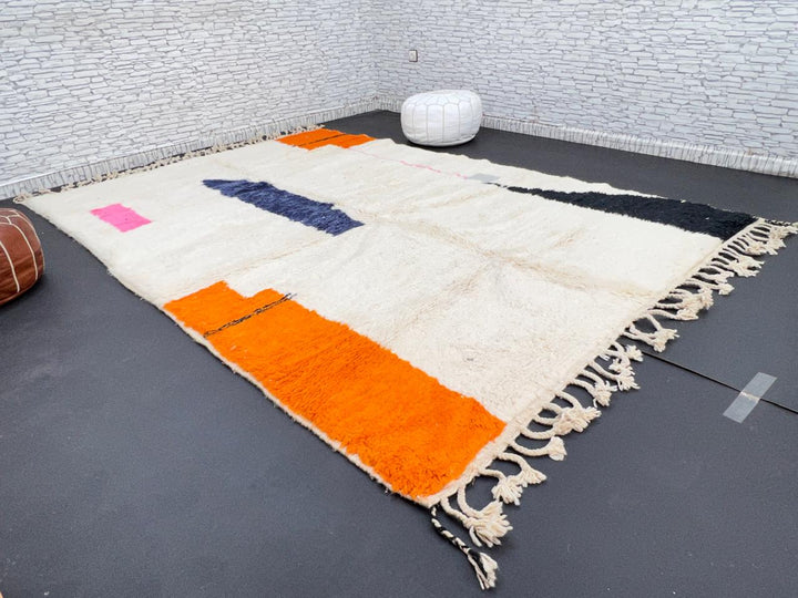 Minimalist Moroccan wool rug with abstract navy, orange and pink line design on cream background