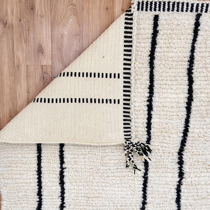 minimalist moroccan wool rug with black linear design on ivory