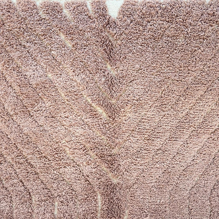 Authentic round Moroccan Berber rug handmade from natural wool with traditional tribal motif in warm beige tones