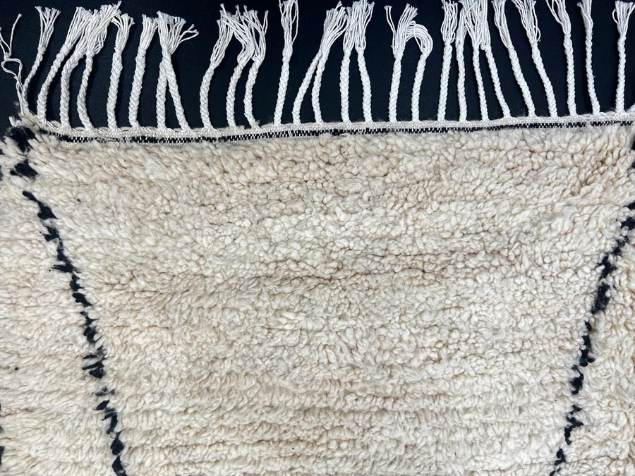 Handmade white Moroccan runner rug with minimalist black geometric line pattern in soft natural wool.