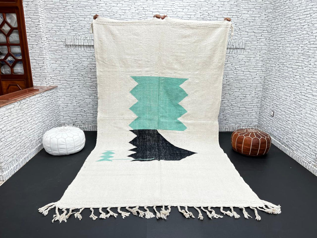 Handwoven Moroccan flatweave wool rug with mint green and black geometric design on ivory background