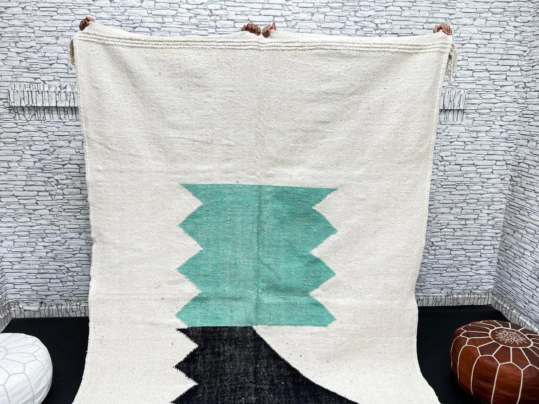 Handwoven Moroccan flatweave wool rug with mint green and black geometric design on ivory background