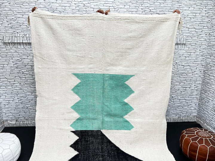 Handwoven Moroccan flatweave wool rug with mint green and black geometric design on ivory background