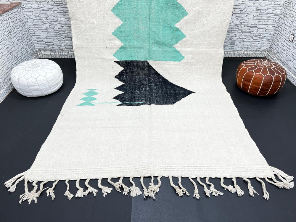 Handwoven Moroccan flatweave wool rug with mint green and black geometric design on ivory background