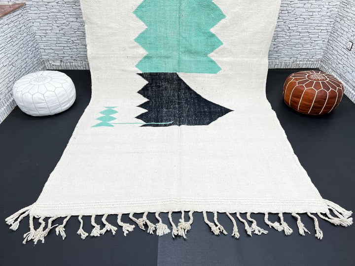 Handwoven Moroccan flatweave wool rug with mint green and black geometric design on ivory background