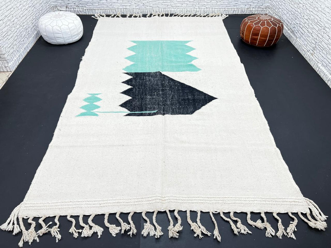 Handwoven Moroccan flatweave wool rug with mint green and black geometric design on ivory background