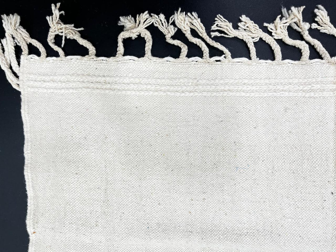 Handwoven Moroccan flatweave wool rug with mint green and black geometric design on ivory background