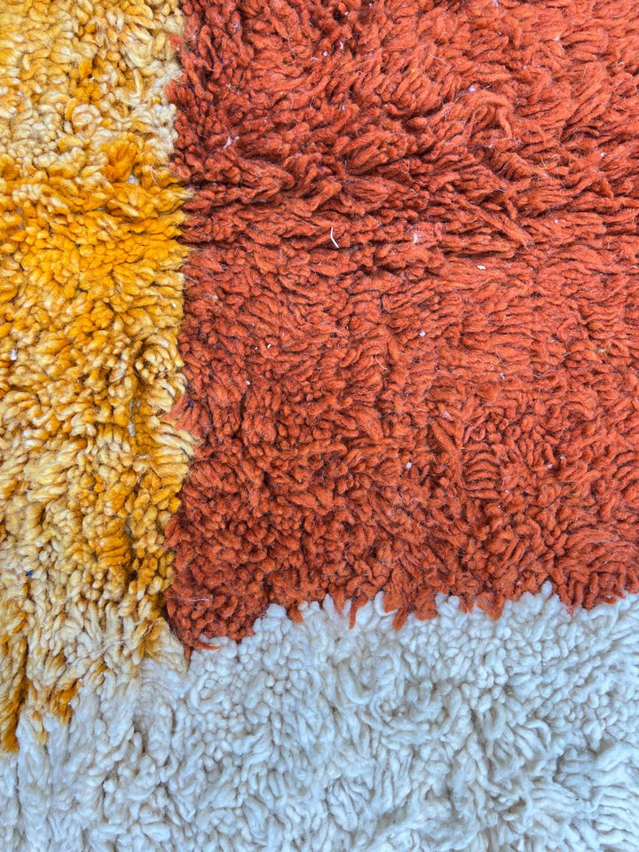 Handmade Moroccan wool rug with modern abstract geometric design in navy, teal, pink, orange, and mustard tones