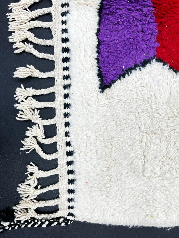 Colorful abstract Moroccan runner rug with artistic face design, handmade wool carpet featuring turquoise, yellow, red and purple shapes on a soft white background, modern boho Moroccan wool runner for hallway decor.