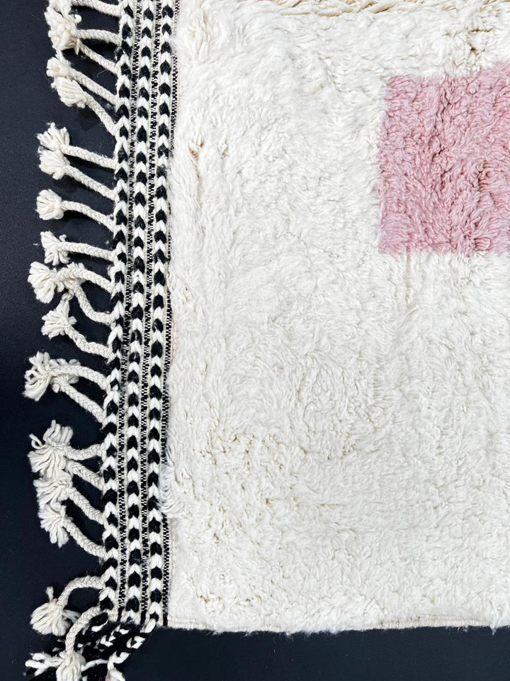 Handmade modern abstract Moroccan wool runner rug with geometric black, green, yellow, and pink design on a white background