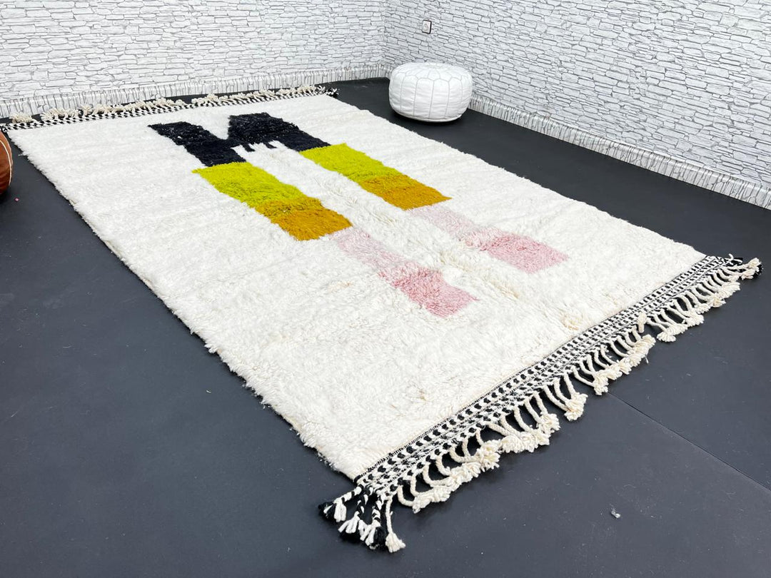 Modern abstract Moroccan wool rug with geometric blocks in black, green, and ochre, handmade by Berber artisans