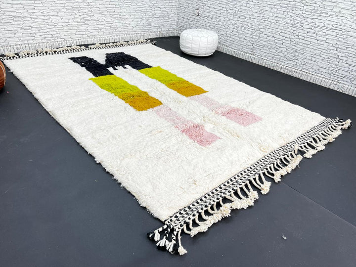 Modern abstract Moroccan wool rug with geometric blocks in black, green, and ochre, handmade by Berber artisans