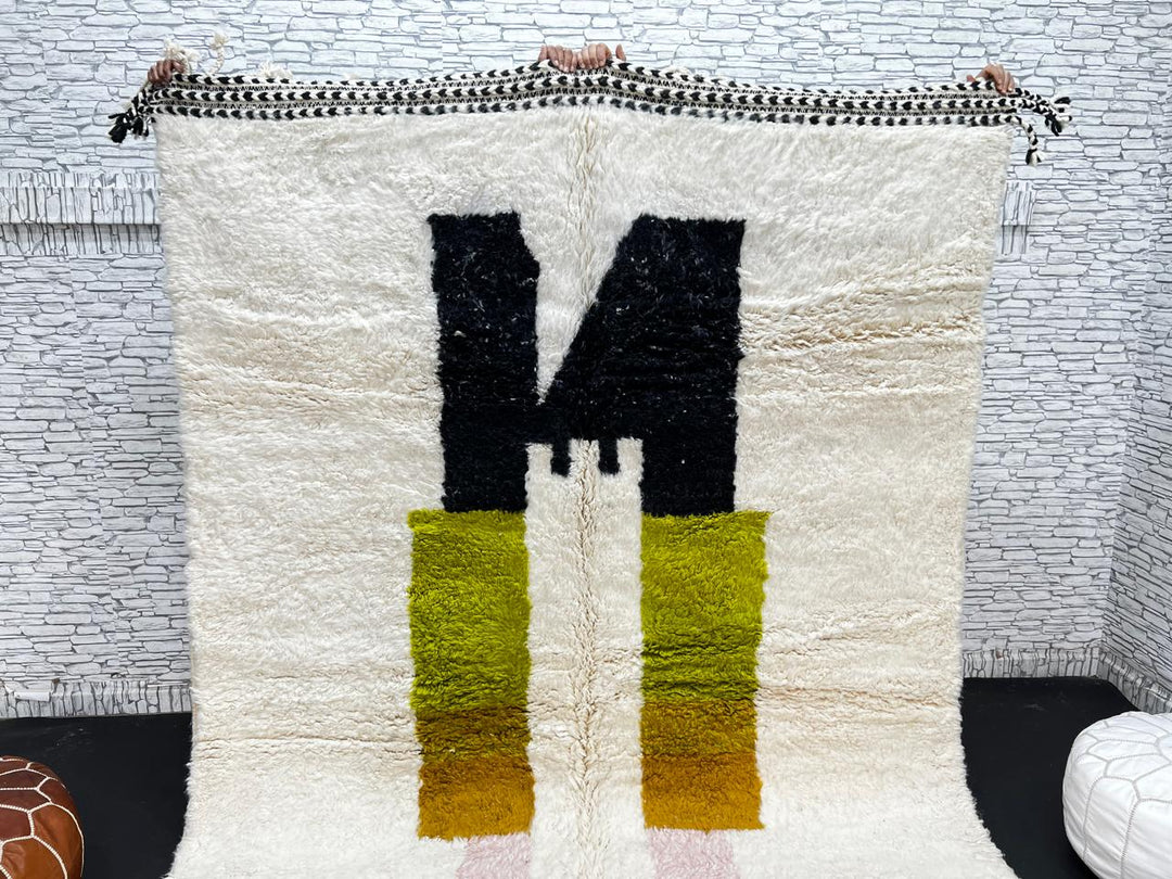 Modern abstract Moroccan wool rug with geometric blocks in black, green, and ochre, handmade by Berber artisans