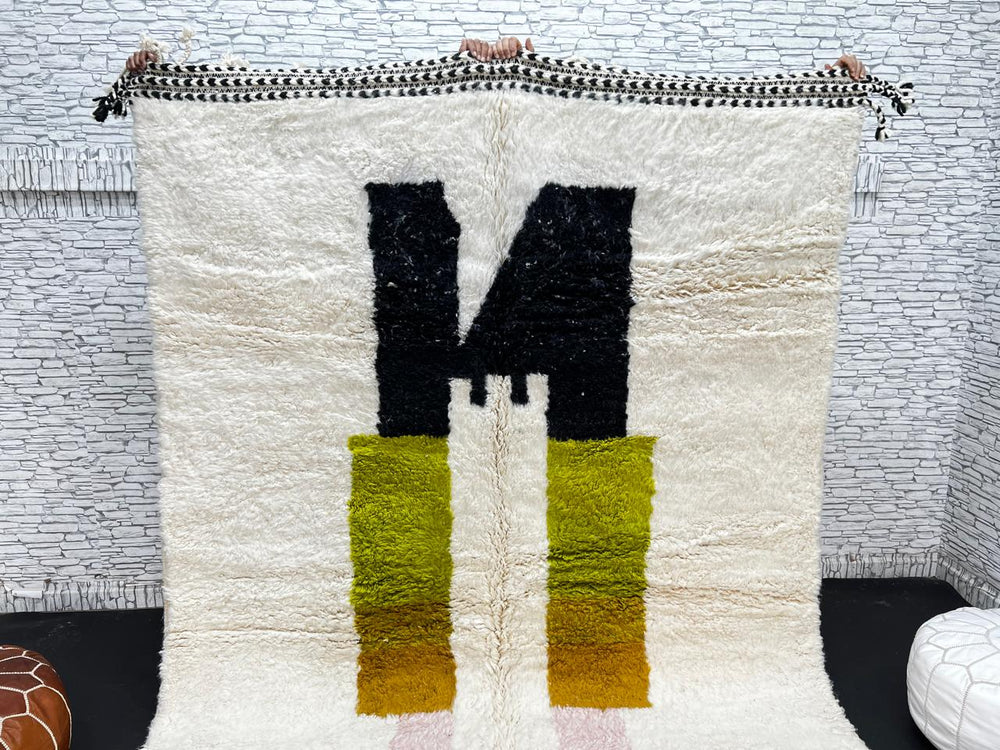 Modern abstract Moroccan wool rug with geometric blocks in black, green, and ochre, handmade by Berber artisans