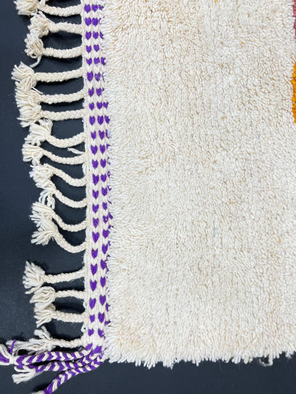 Handmade modern Moroccan wool runner rug with bold abstract geometric shapes in purple, fuchsia, orange, and green on a white background