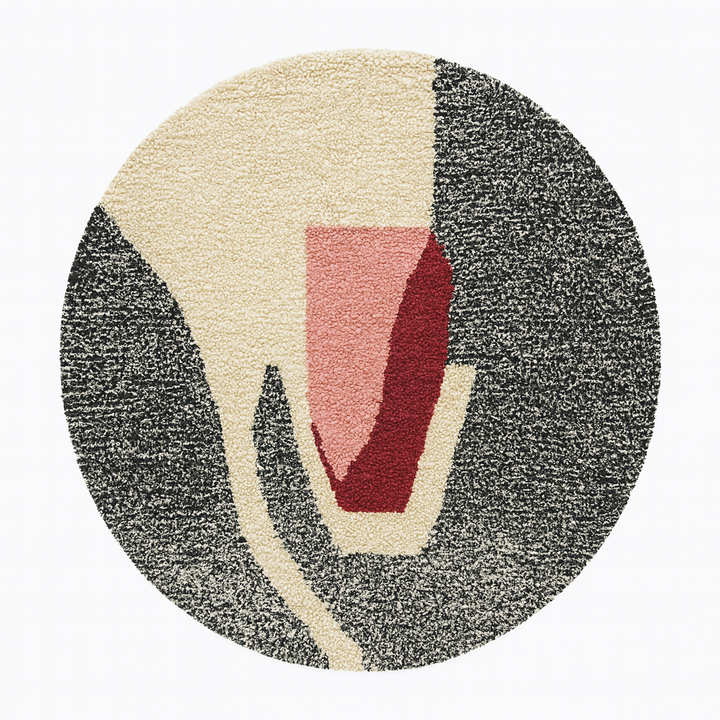 Round modern Moroccan rug with abstract pink, red, black, and white pattern.