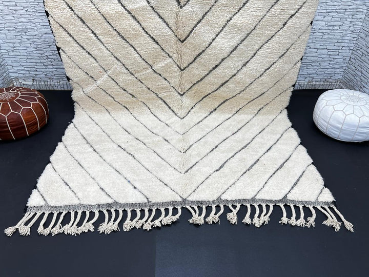 Modern Moroccan Beni Ourain wool rug with black chevron lines on cream background, handmade by Berber artisans