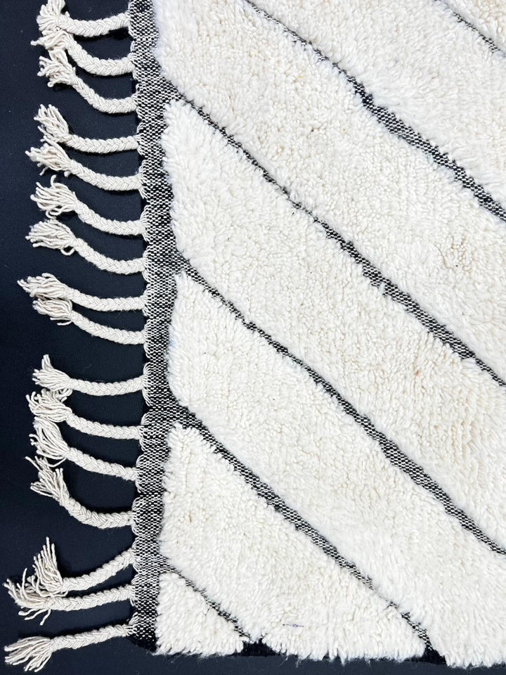 Modern Moroccan Beni Ourain wool rug with black chevron lines on cream background, handmade by Berber artisans
