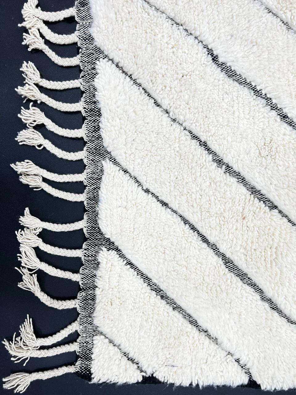 Modern Moroccan Beni Ourain wool rug with black chevron lines on cream background, handmade by Berber artisans
