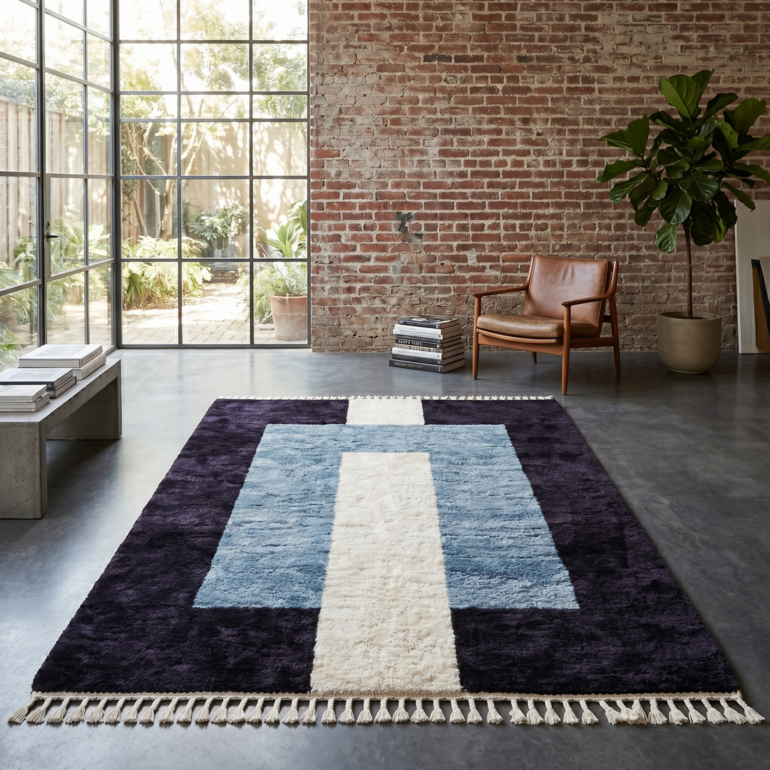 Handmade modern Moroccan wool rug featuring black, blue, and cream geometric block design with soft texture and fringe tassels.